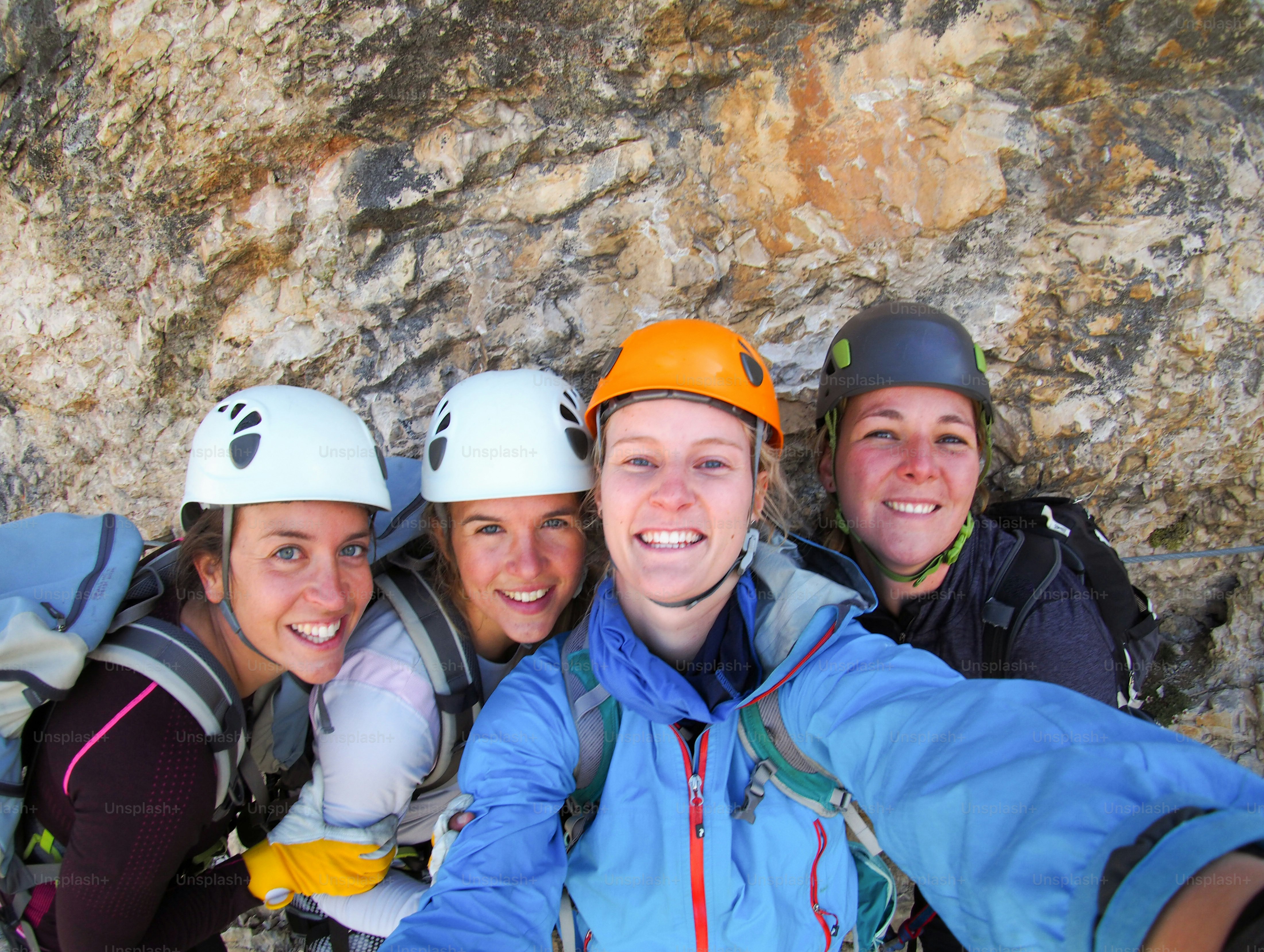 View of four female climbers celebrating on the mountain summit by