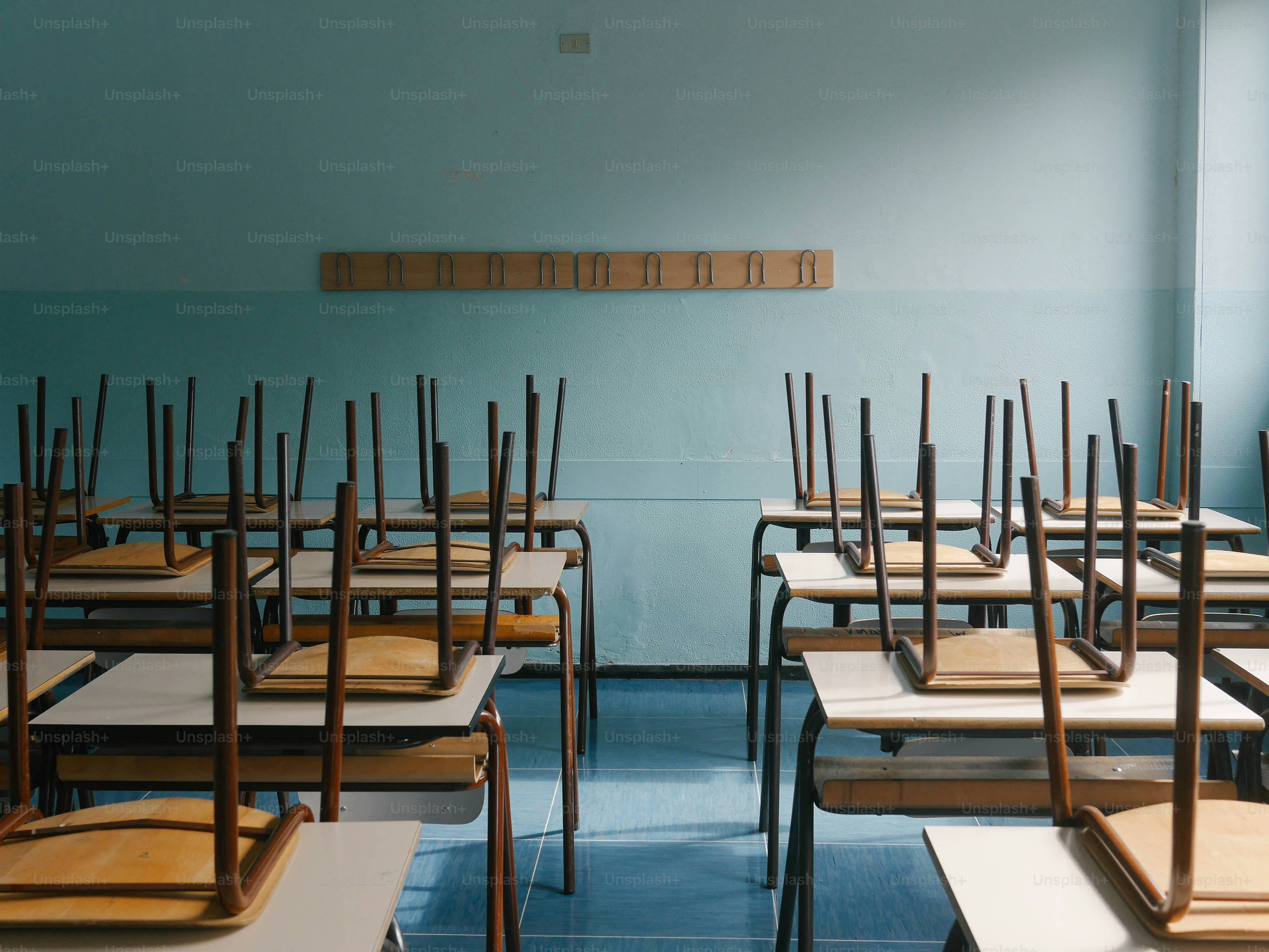 A row of wooden desks in a classroom photo School Image on Unsplash