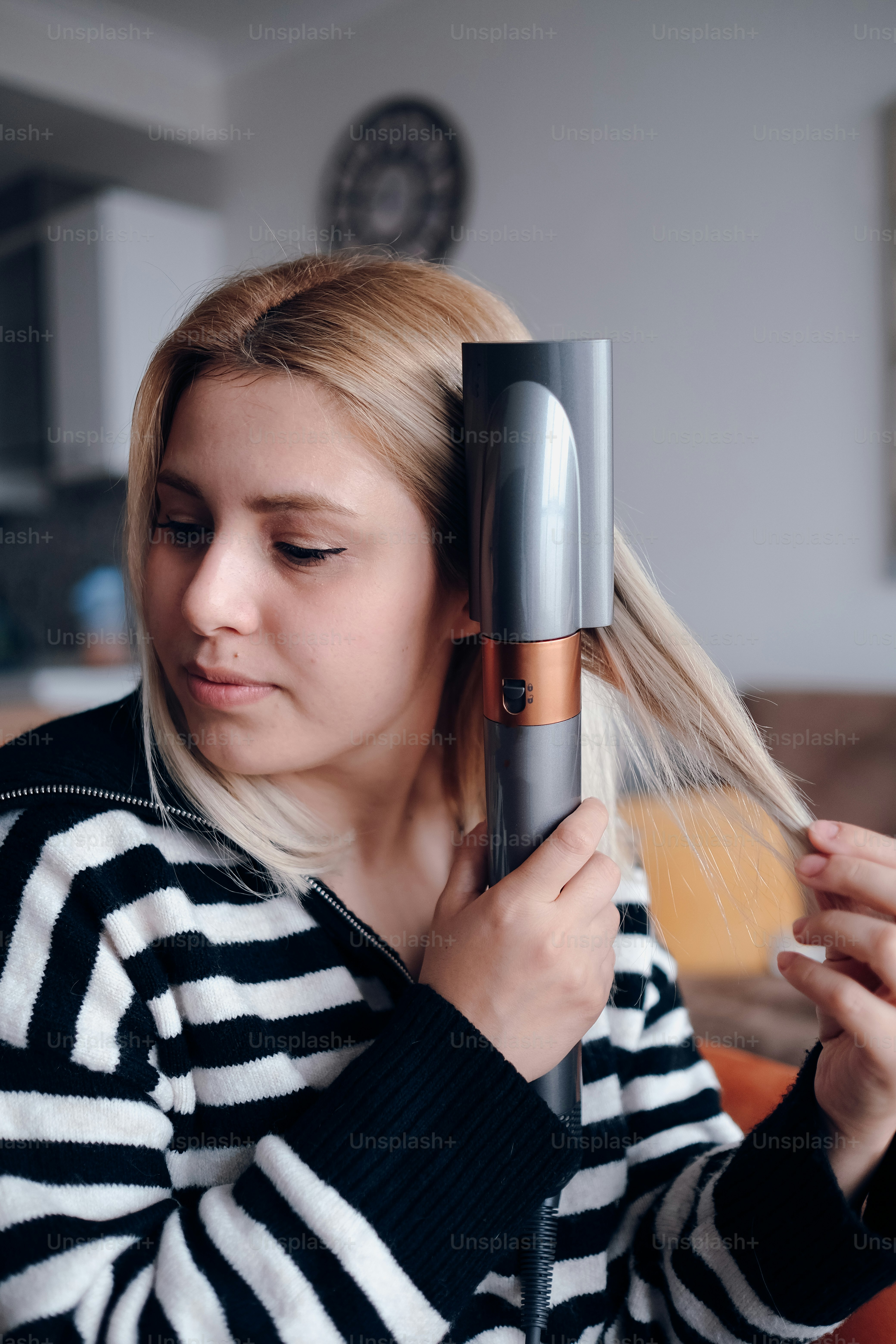 A woman blow drying her hair with a hair dryer photo Personal care