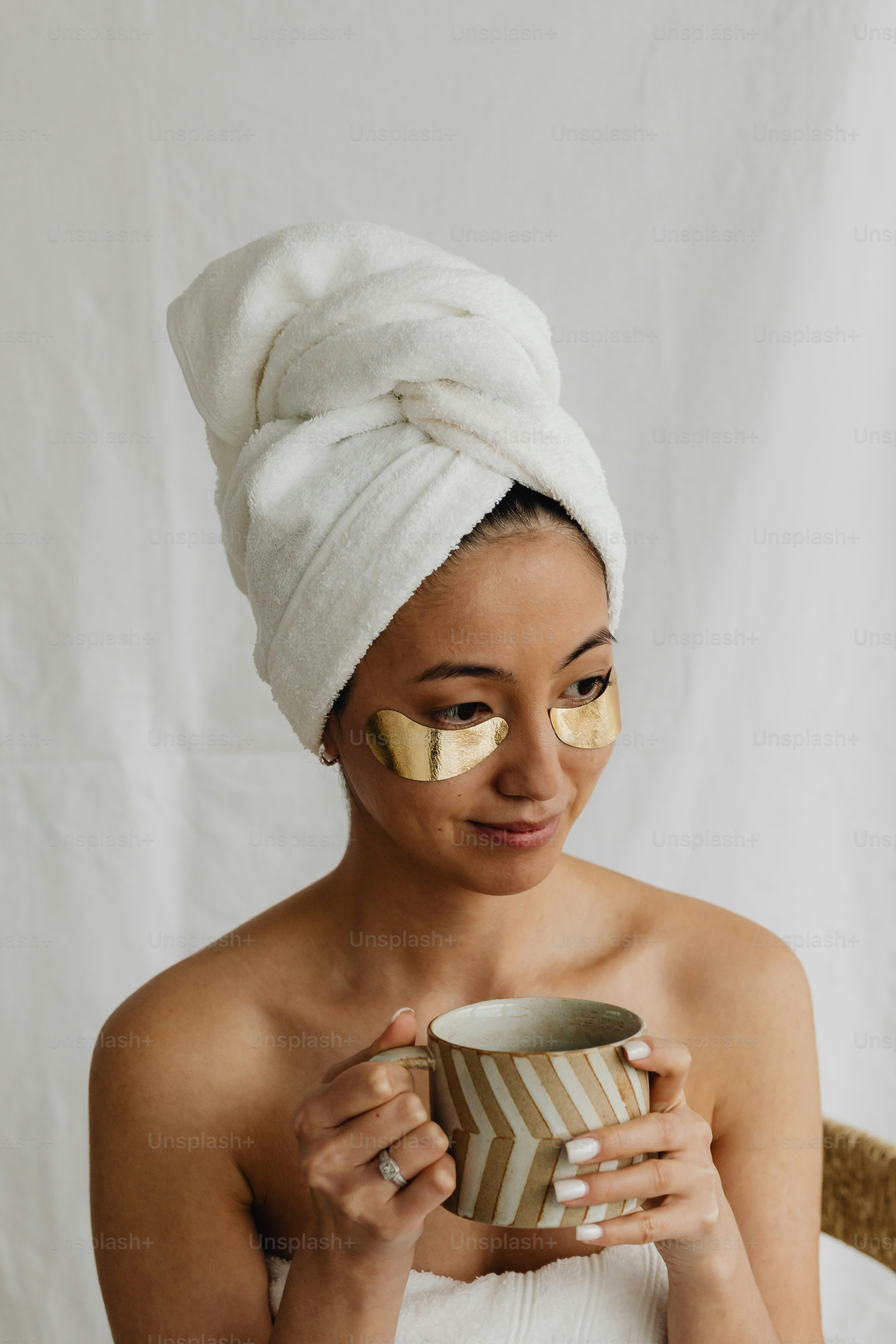 A woman with a towel on her head and a drop of liquid on her forehead