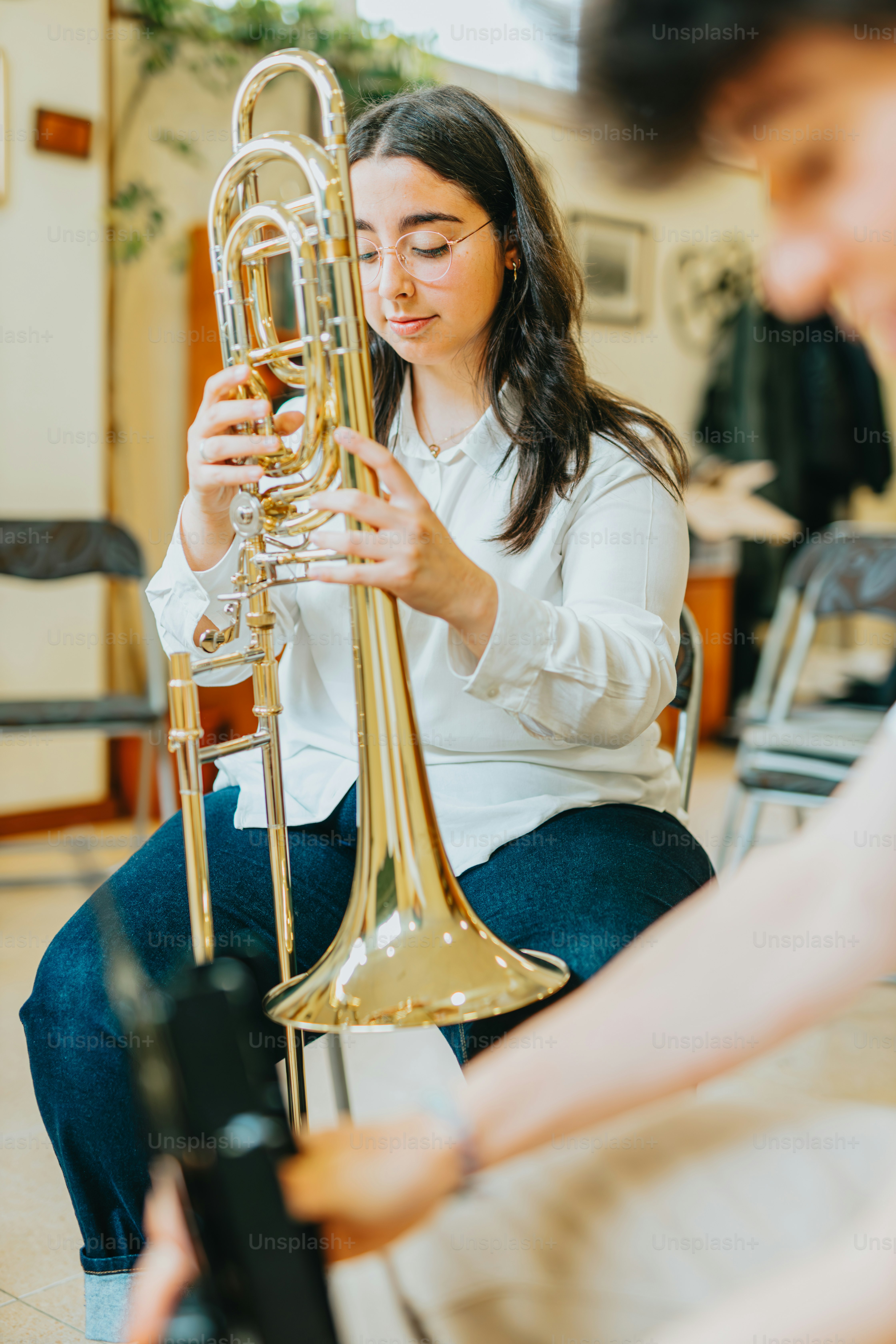 A woman sitting on a chair playing a trumpet photo Trumpets Image on