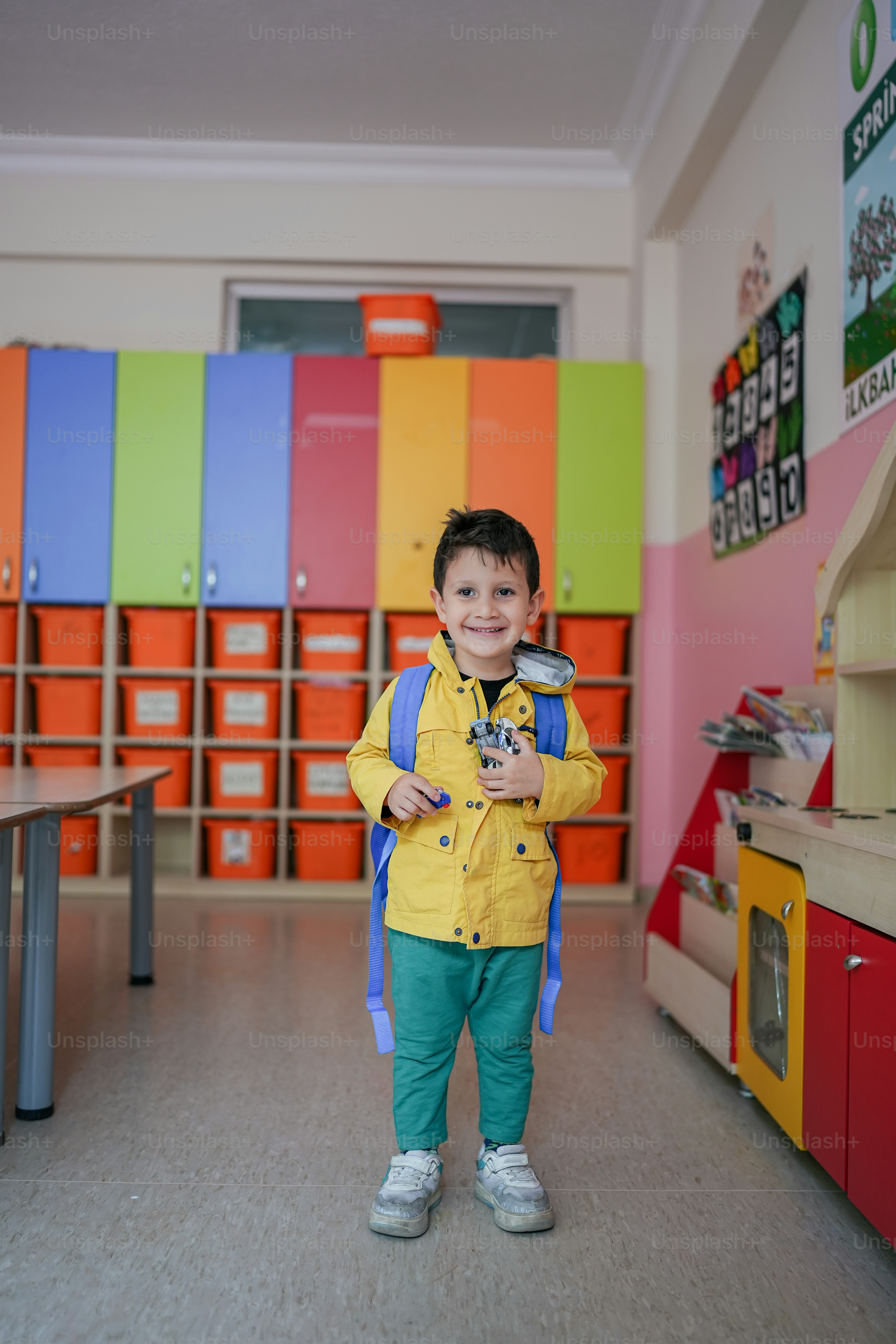Un jeune garçon debout devant un mur coloré photo École maternelle