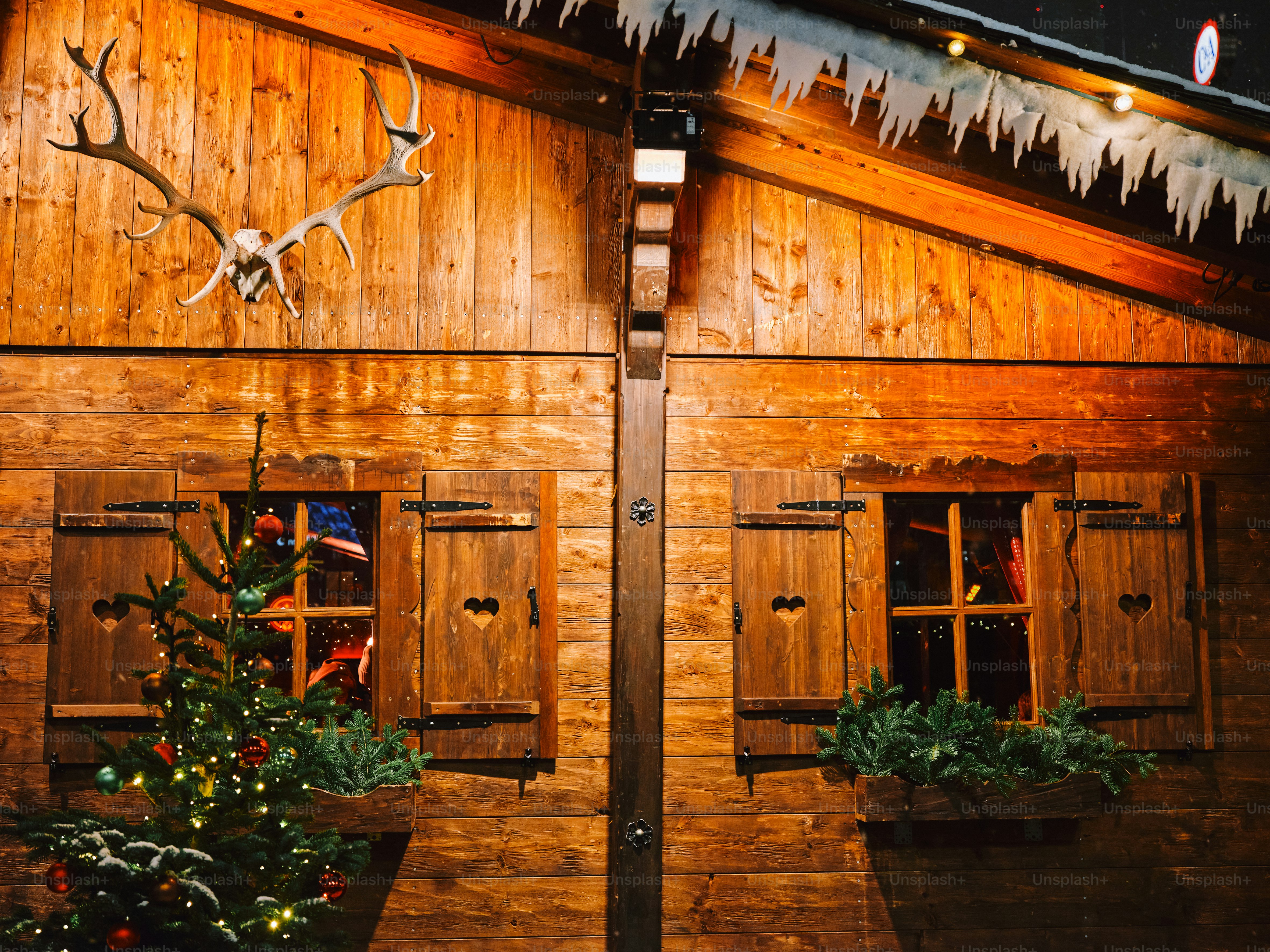 A wooden building with a christmas tree in front of it photo Christmas Image on Unsplash