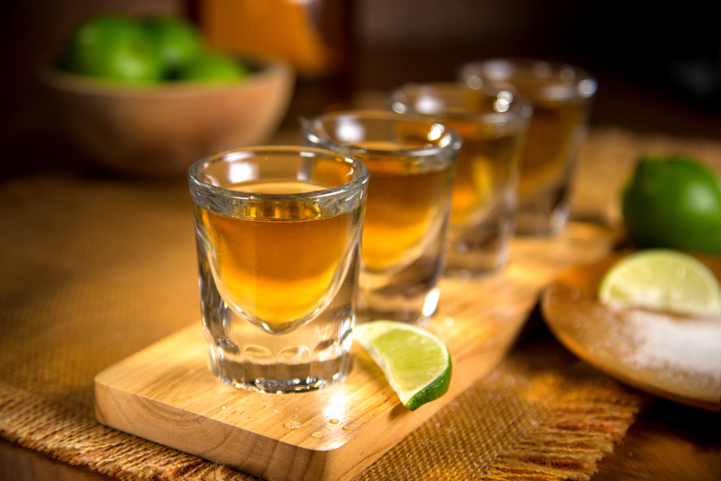 Close up of agave traditional Tequila shots flight with cut limes and