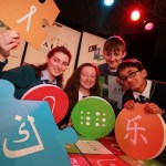 Four students pictured holding large puzzle pieces