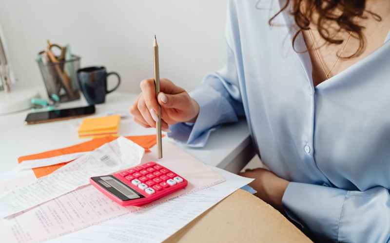a woman computing bills while holding a pencil