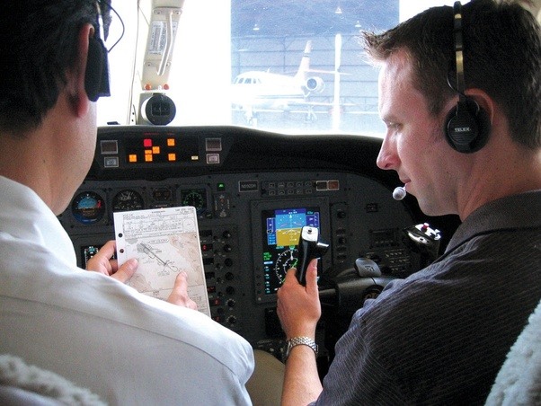 What is the pay of an instructor pilot in a flying school compared to