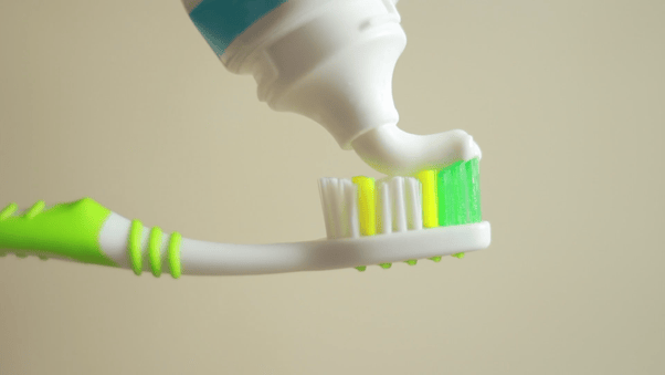 What is the correct way to water toothbrush, before putting toothpaste