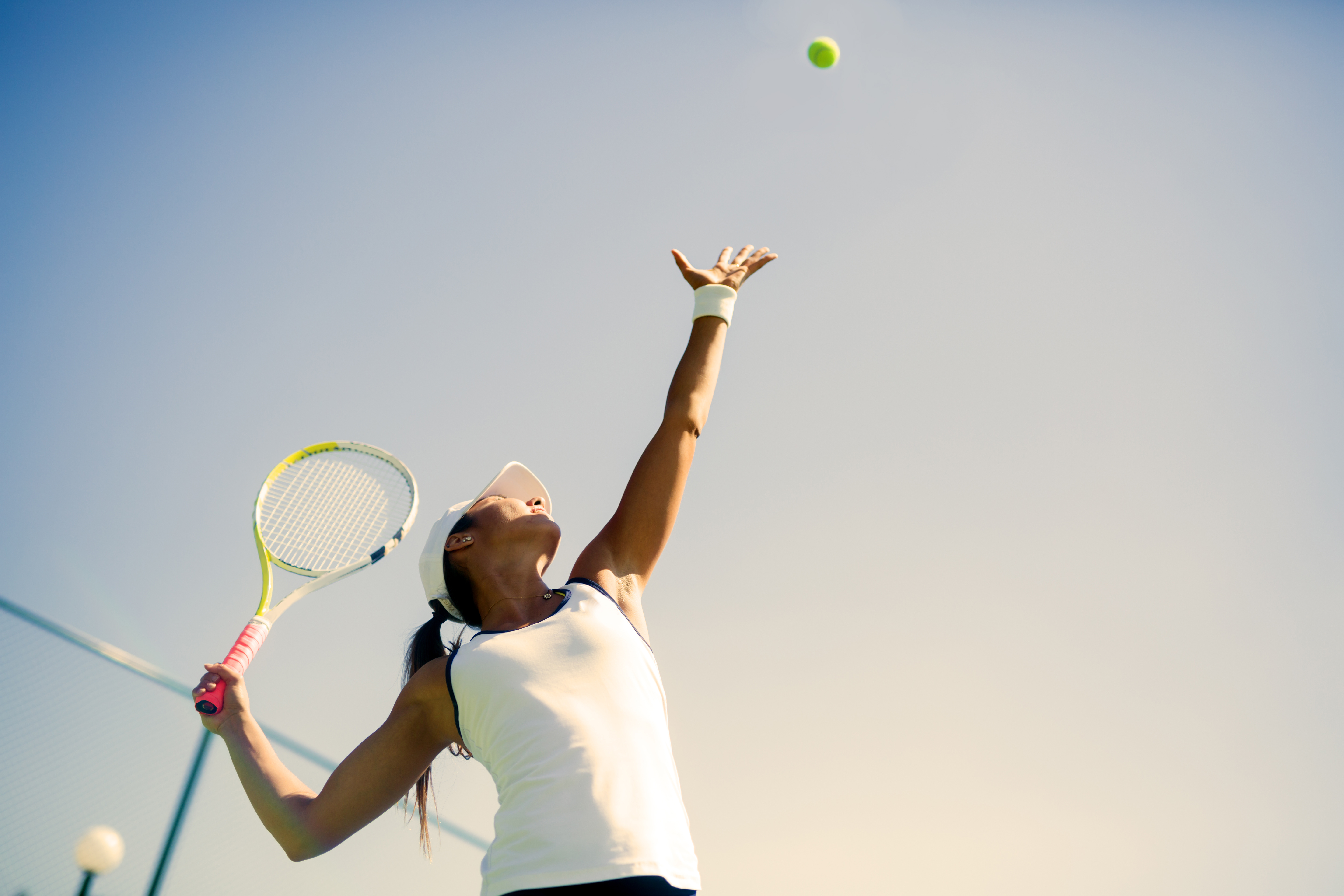 Beautiful female tennis player serving RegenOrthoSport Orthopedic