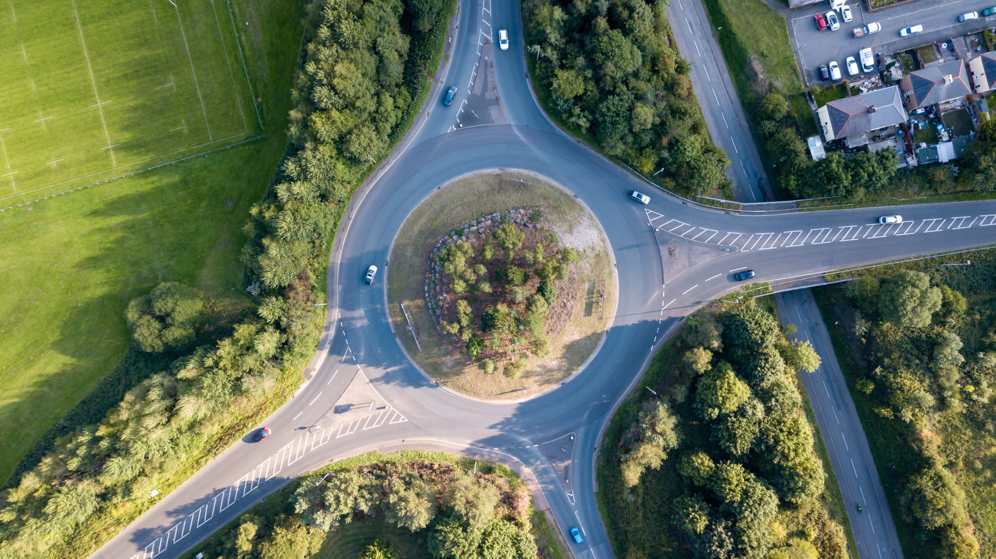 Top down aerial view of a traffic roundabout on a main road in an urban