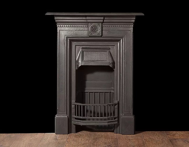 A small antique castiron bedroom fireplace