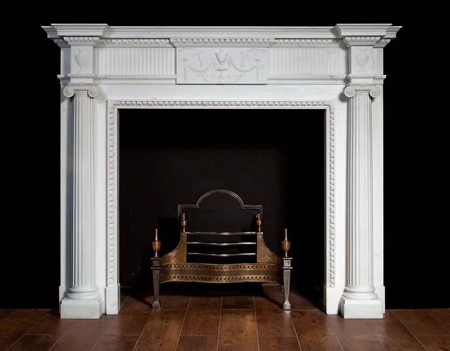 A pure white marble fireplace in the neoclassical taste