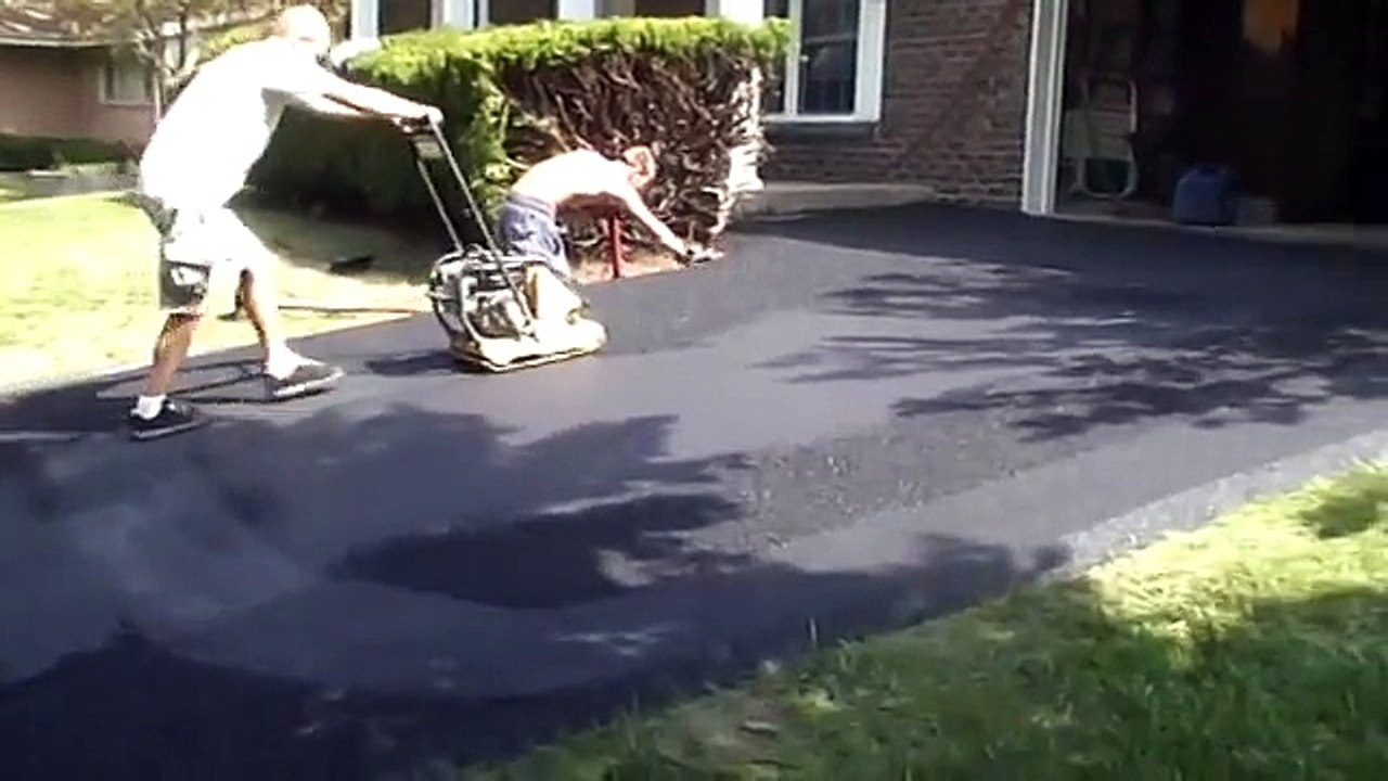 Operating a plate compactor or wacker on asphalt driveway in Saint
