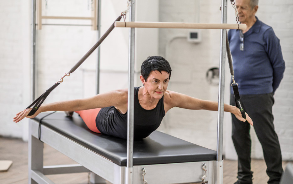 Photo of Jay Grimes working with student on a Contrology Cadillac