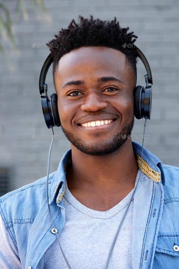 Close up cool young black guy listening to music with headphones Stock