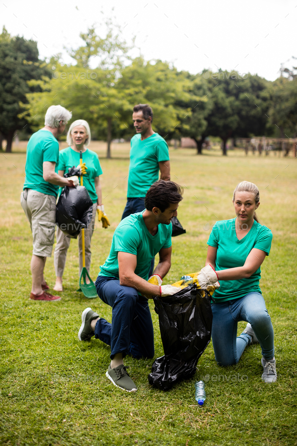 Team of volunteers picking up litter Stock Photo by Wavebreakmedia