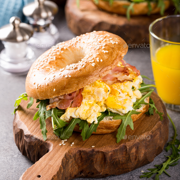 Freshly baked bagel filled with scrambled eggs Stock Photo by Merinka