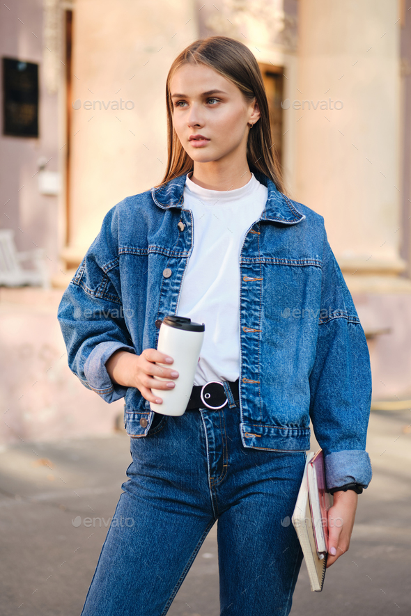 Young serious stylish student girl in denim jacket thoughtfully looking