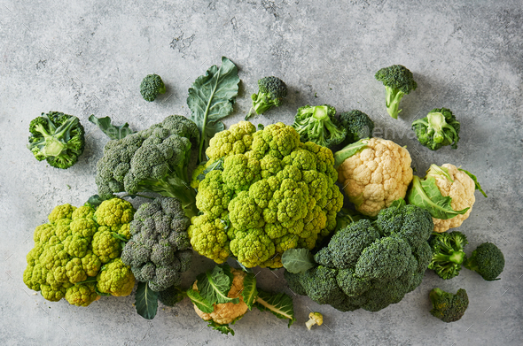 Fresh green cabbage, cauliflower and broccoli on a light textured