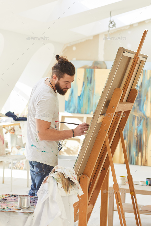 Male Artist Painting in Art Studio Stock Photo by seventyfourimages