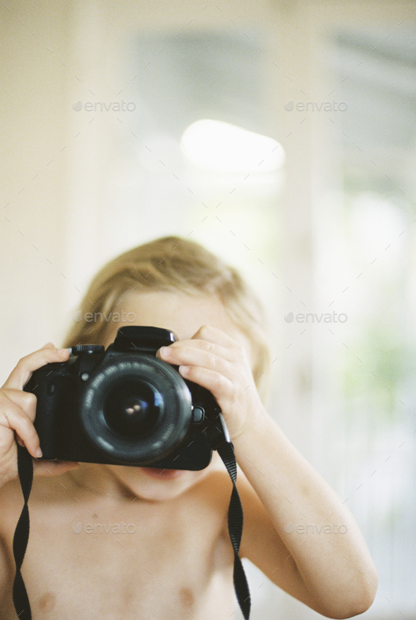Young nude girl taking a picture with a camera. Stock Photo by Mint_Images