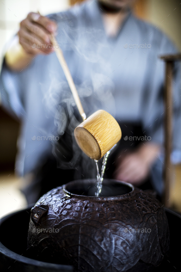 Traditional Japanese Tea Ceremony, man using a Hishaku, a bamboo ladle