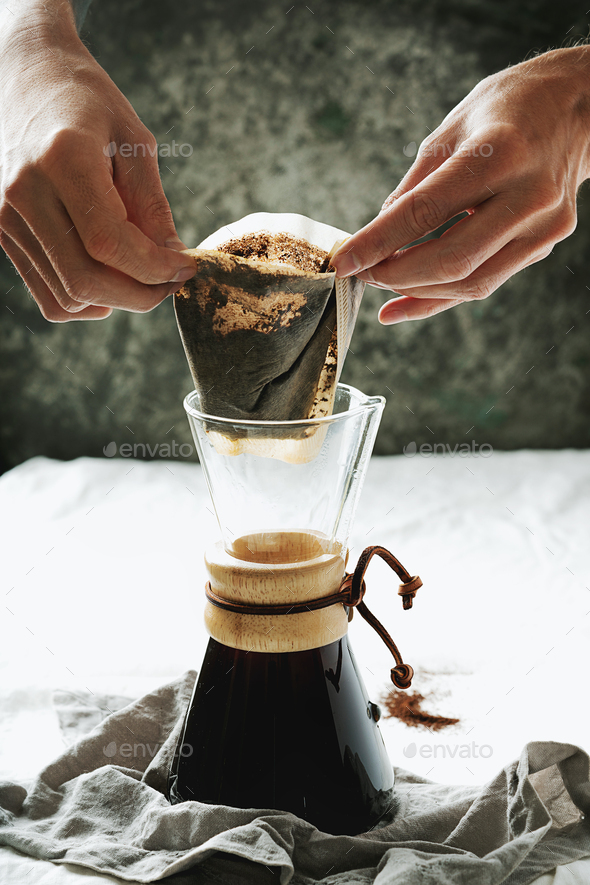 Preparing pour over, filtered coffee with dripper, putting ground coffe