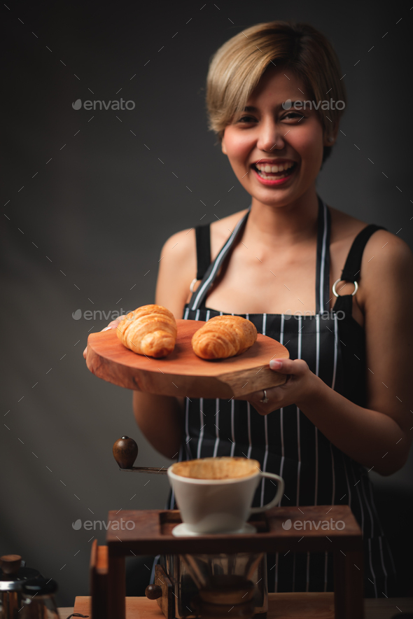 Baker presenting freshly baked croissants in cafe that made of puff