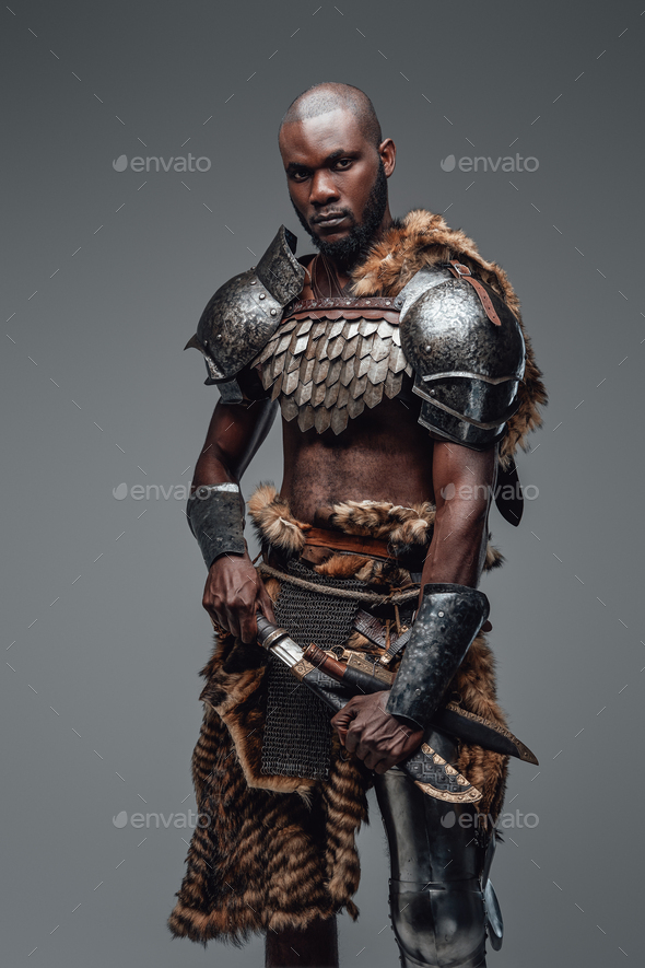 Wild ancient soldier with shaved head and black skin with a blade Stock