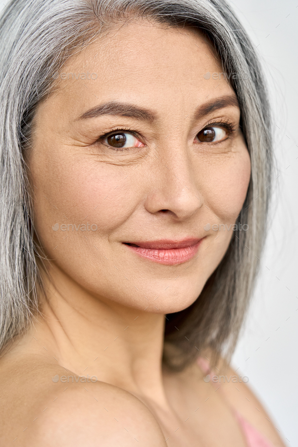 Closeup of Asian mature mid age woman of 50s looking at camera. Stock