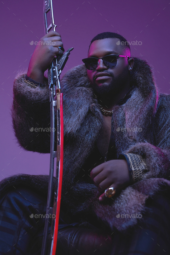 Dangerous black man with sword sitting on armchair Stock Photo by fxquadro