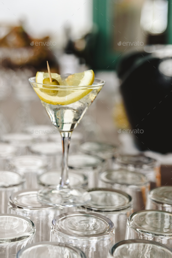 Cup of gin and tonic, with a slice of lemon and olive. Stock Photo by