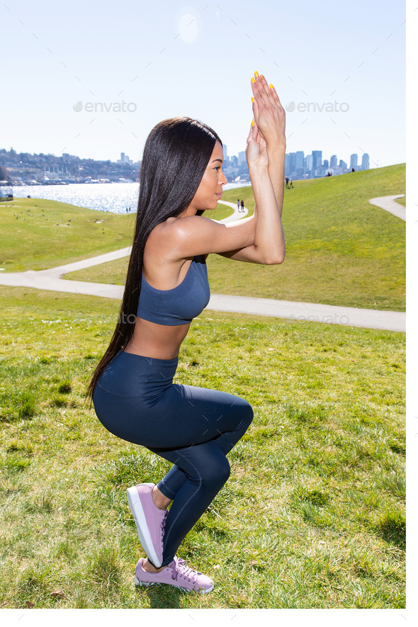 Beautiful woman with long black hair wearing yoga pants and sports bra