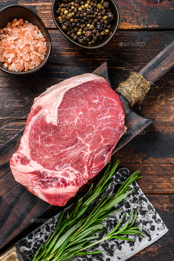 Raw beef meat Club or striploin on the bone steak. Dark wooden