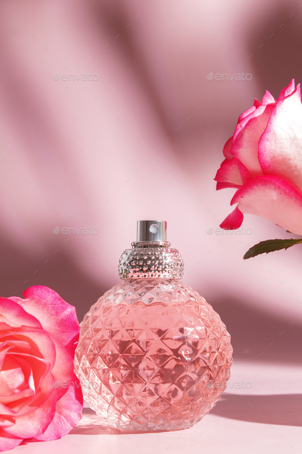 Perfume bottle and rose flowers. Concept of expensive perfume and