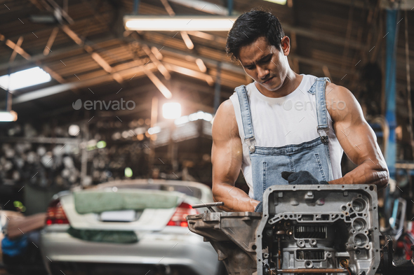 Handsome young male mechanic and car repair service man using various