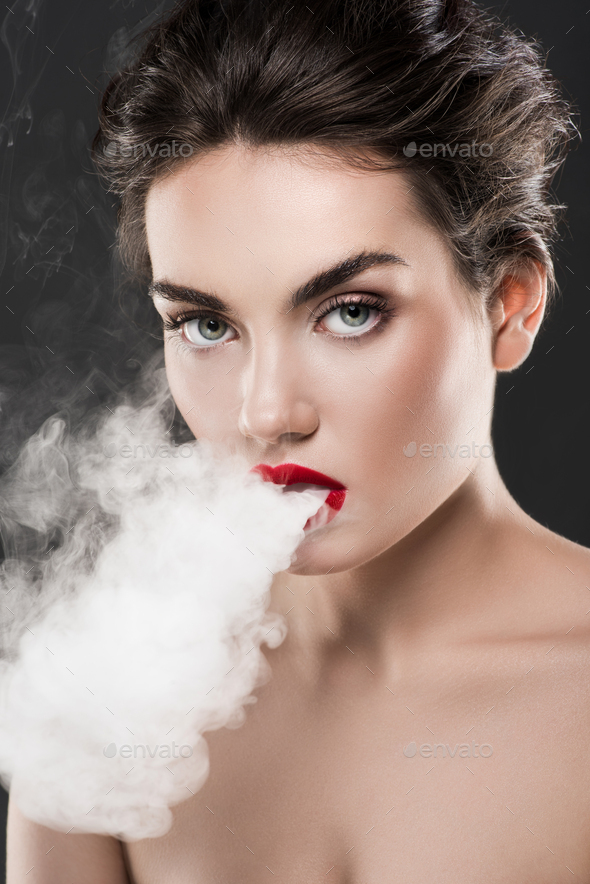 stylish naked woman blowing smoke, isolated on grey Stock Photo by