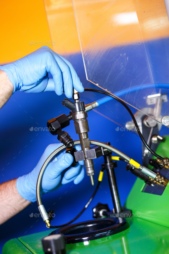 Professional mechanic testing diesel injector in his Stock