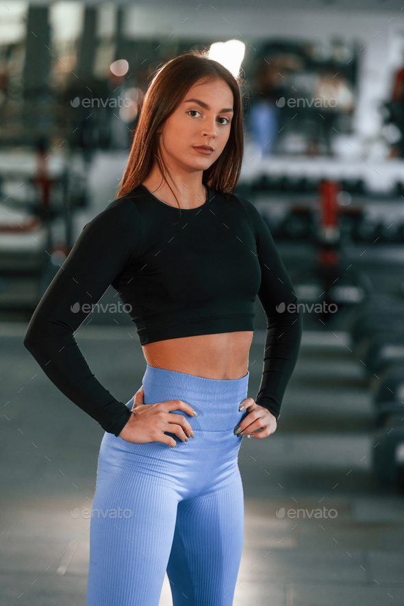 Side view. Standing and posing. Beautiful woman with sport body type is