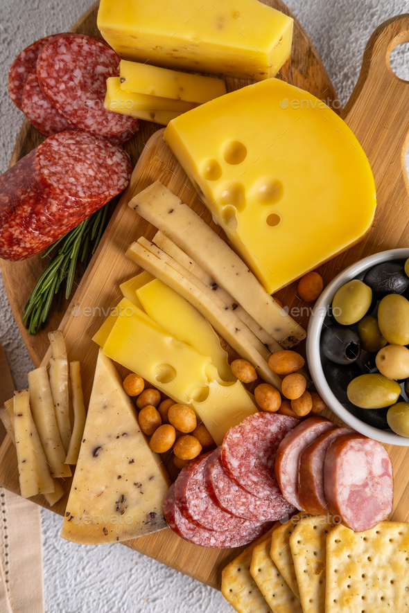 Different types of cheeses and cold cut meats. Top view on a white