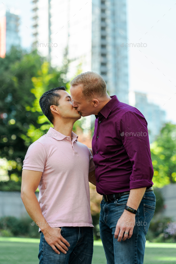 Happy middle aged gay couple kissing outdoors. Love, relationship, date