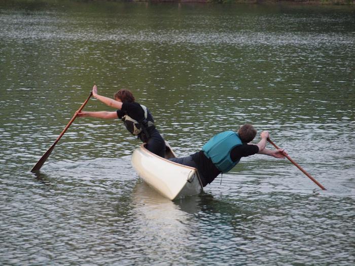 Three people paddling one canoe