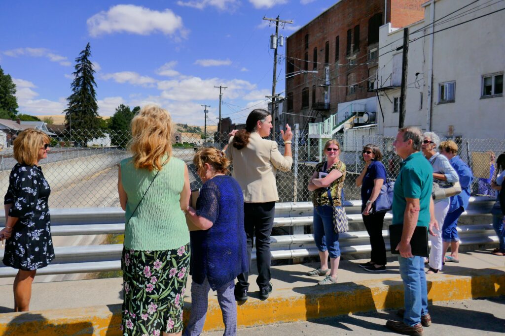 A group walking through the streets of Colfax, Washington, pauses on a bridge to consider possibilities. Photo by Sarah McKnight.