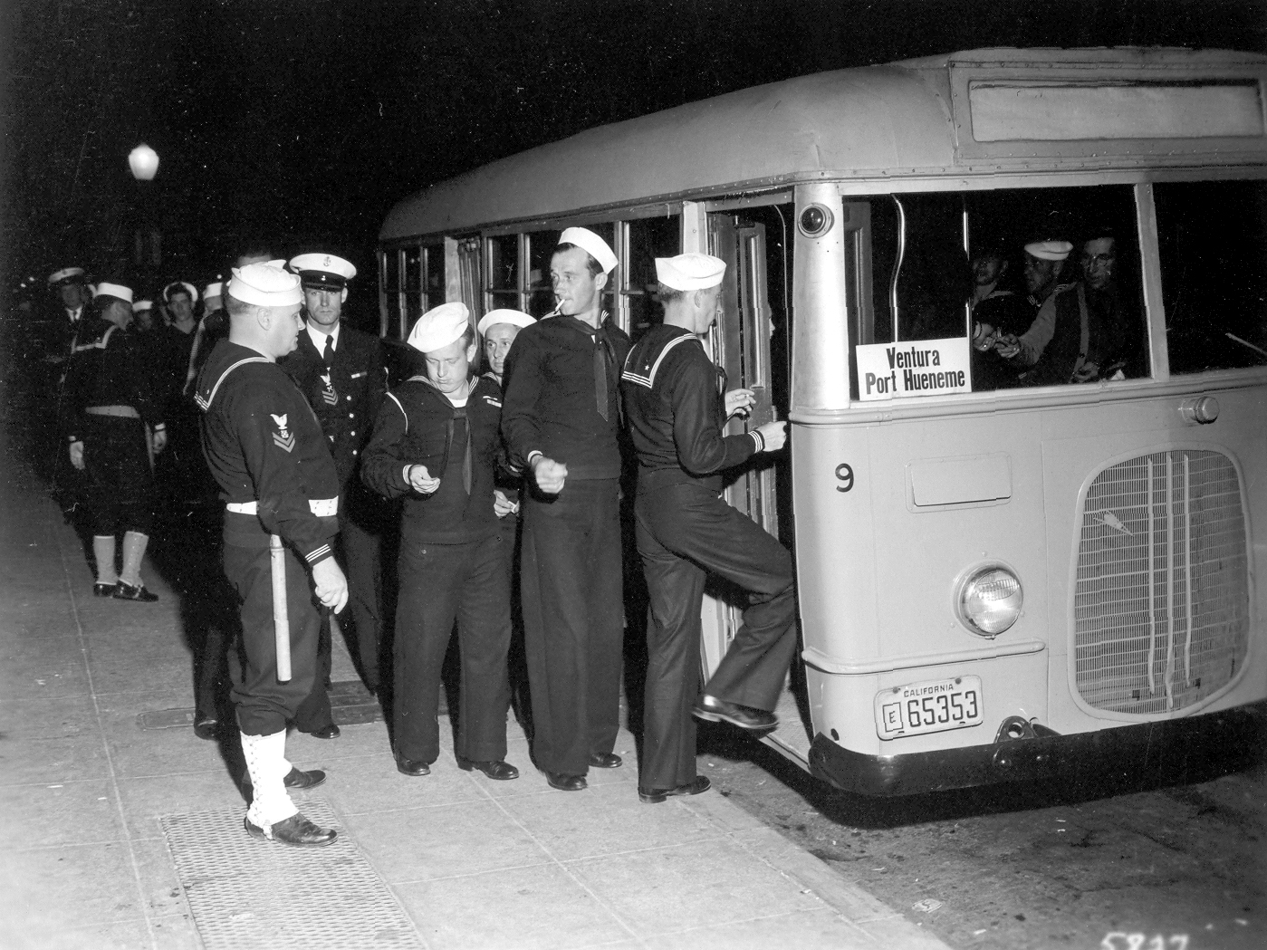 BM2c R.O. Babbitt, a member of the Shore Patrol, regulates departure of