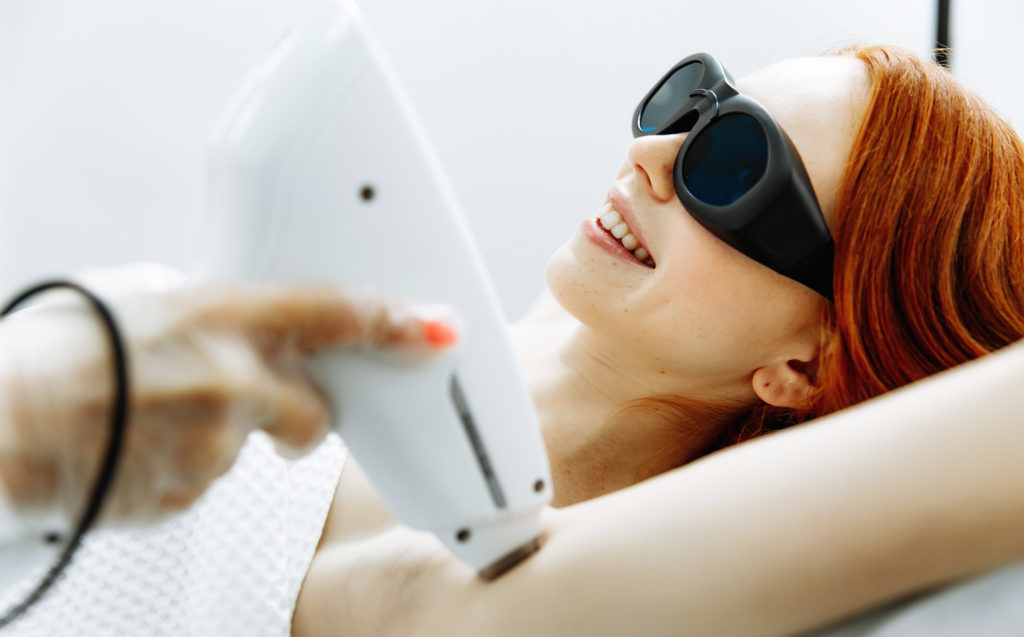 Hair Removal young woman receiving laser hair removal epilation on face