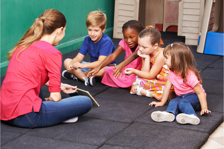 This is an image of a teacher and students in a reading group to see if anyone needs a speech referral