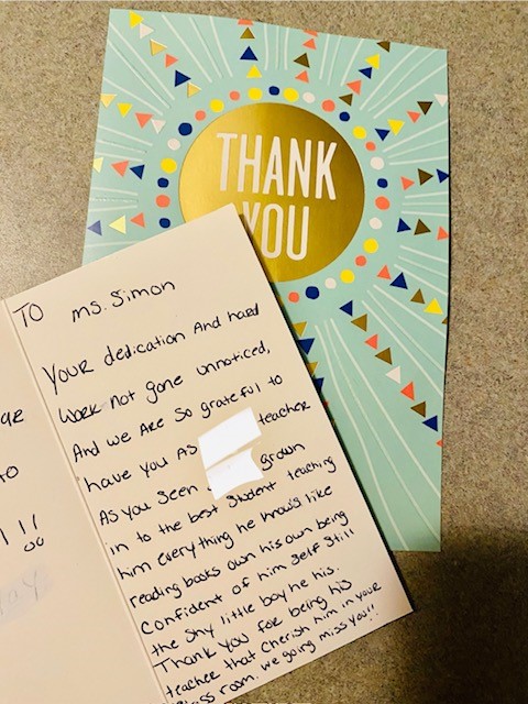 A greeting card with a handwritten note from a parent to a teacher