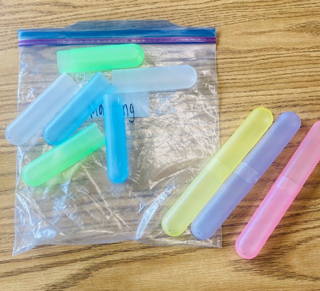 A matching task box activity with different colored toothbrush holders