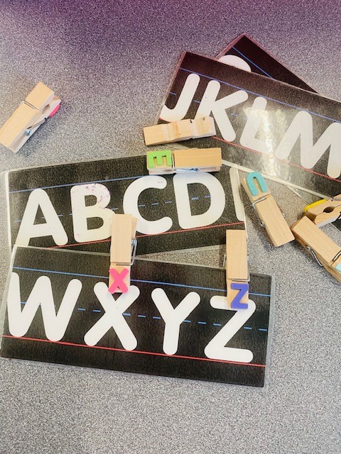 Black and white strips of alphabet letters with matching alphabet clothespins