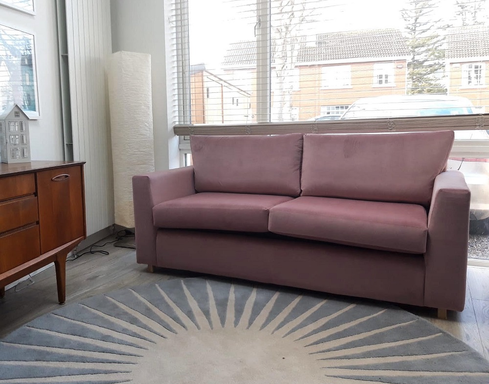 A blush pink velvet sofa equipped with a bedsettee. LOVE the colour